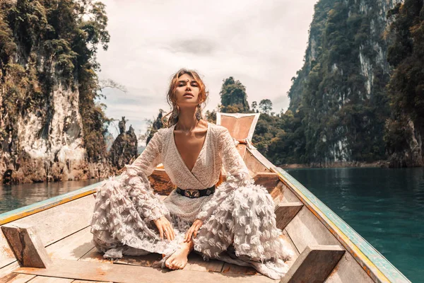 Modny młody model w eleganckiej sukni na łodzi na jeziorze — Zdjęcie stockowe