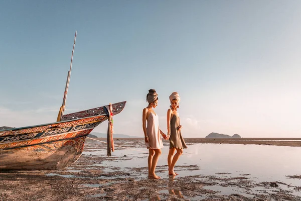 Dos hermosas modelos de moda joven en la playa en barco de mar — Foto de Stock