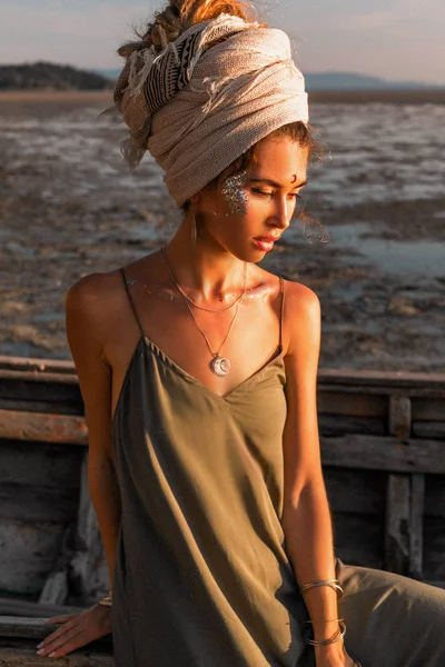 Belo modelo de moda jovem na praia no barco do mar ao pôr do sol — Fotografia de Stock