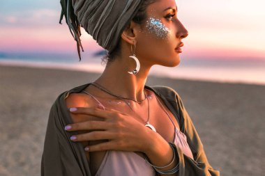 beautiful young fashion model on the beach at sunset portrait clipart