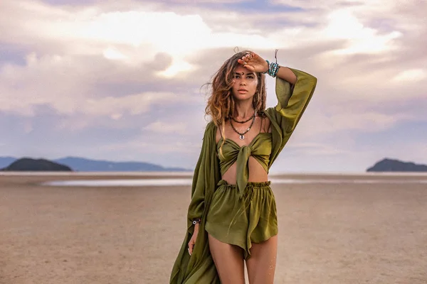 Bela jovem mulher em traje elegante na praia ao pôr do sol — Fotografia de Stock