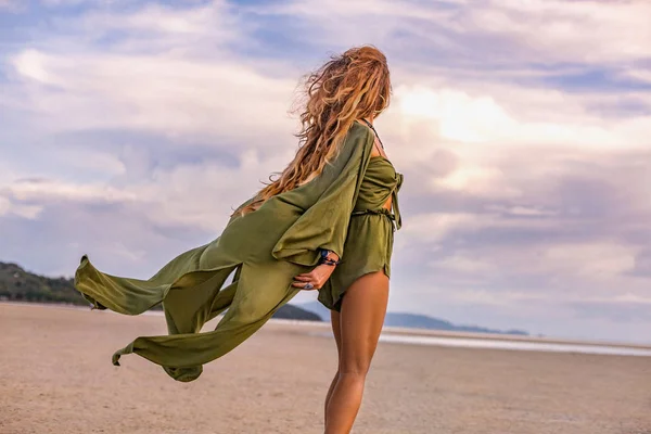 Όμορφη νεαρή γυναίκα σε κομψό κοστούμι στην παραλία στο ηλιοβασίλεμα — Φωτογραφία Αρχείου