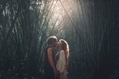 gün batımında bambu ormanında açık havada öpüşme genç çift