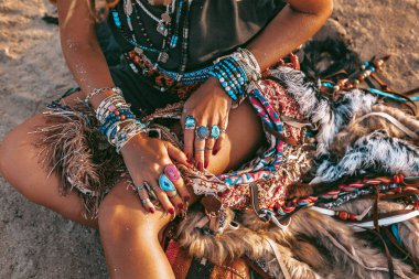 plajda kum üzerinde oturan genç boho tarzı kadın yakın çekim 