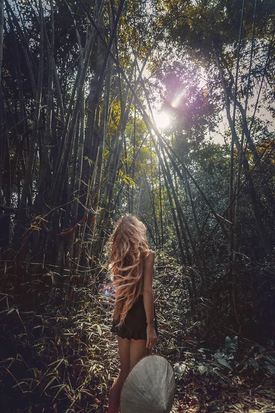 Schöne junge Touristin mit Hut im Bambuswald — Stockfoto
