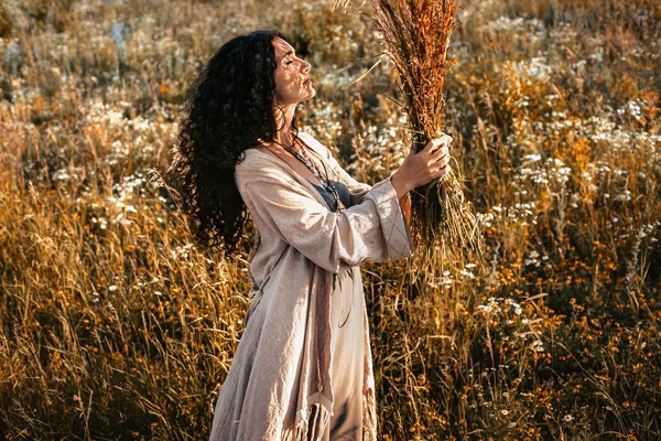 Bela jovem mulher em um campo ao pôr do sol — Fotografia de Stock