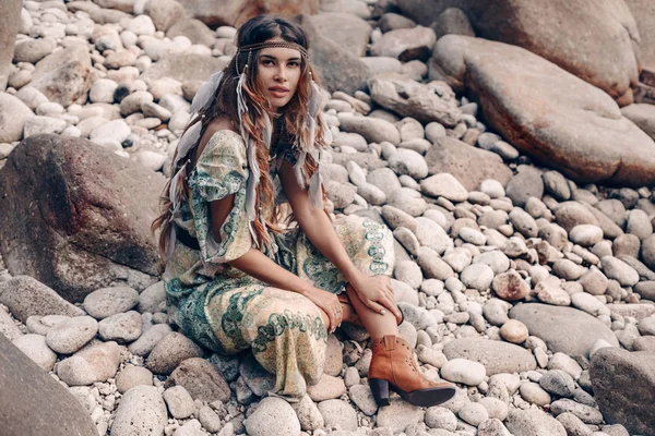 Taş plajda oturan çekici genç moda kadın — Stok fotoğraf