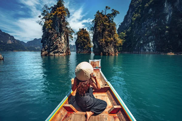 Joven turista en asiático sombrero en el barco en el lago — Foto de Stock