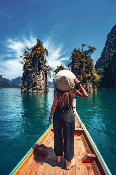 Joven turista en asiático sombrero en el barco en el lago — Foto de Stock