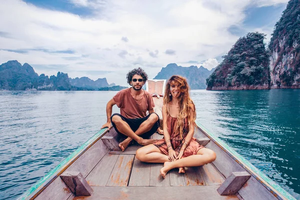 Joven hombre y mujer turistas sentados en la proa del barco — Foto de Stock