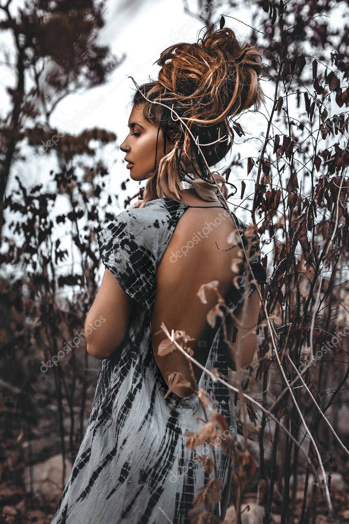 portrait of beautiful young woman through the dry branches 