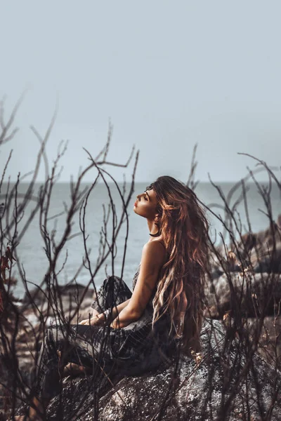 Портрет красивой молодой женщины через сухие ветви на открытом воздухе — стоковое фото