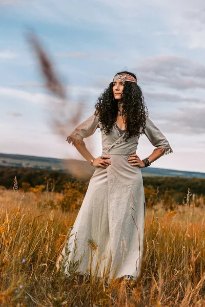 Schöne junge Frau auf einem Feld bei Sonnenuntergang — Stockfoto