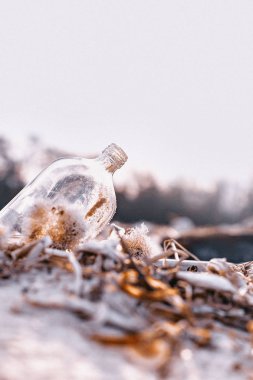 Kumsalda kumsalda duran boş cam şişe. 