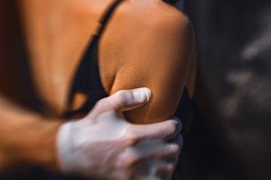 Sarılan genç çift yüz maskesi ve tıbbi eldiven takıyor.