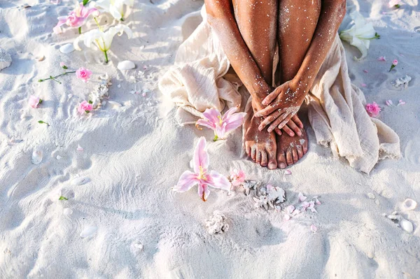 日落时在海滩上把漂亮的年轻女子的腿围在一起 — 图库照片