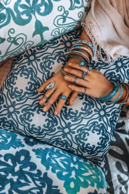 Modacıların yastıklarına uzanan aksesuarlı kadın ellerini kapat.