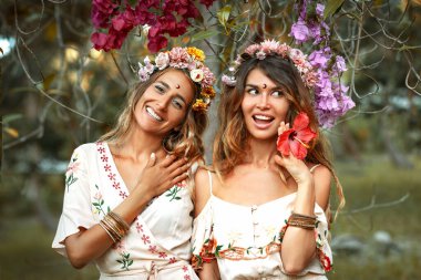 Yazlık giyimli iki güzel kadın açık havada giyiniyor. 