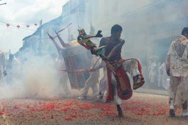 Phang Nga, Tayland - 14 Ekim 2018: Grup tahtırevan içinde sokakta yürüyen insanlar ibadet Tanrı Phang Nga, Tayland vejetaryen Festivali geçit havai fişek ateş ederken Çin Tanrı heykeli ile holding beyaz elbiseli adam