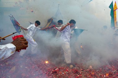 Phang Nga, Tayland - 14 Ekim 2018: Grup tahtırevan içinde sokakta yürüyen insanlar ibadet Tanrı Phang Nga, Tayland vejetaryen Festivali geçit havai fişek ateş ederken Çin Tanrı heykeli ile holding beyaz elbiseli adam