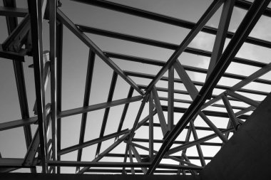Structure of steel roof frame for building construction. Black and white photo. clipart
