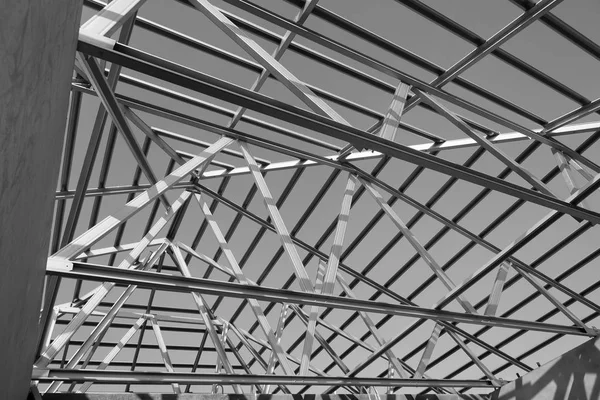 Structure of steel roof frame for building construction. Black and white photo.