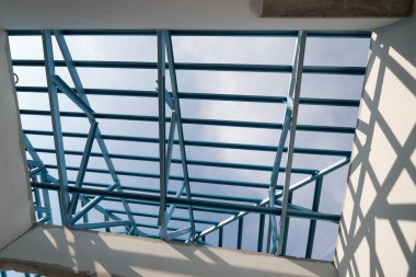 Bina inşaat mavi gökyüzü arka plan üzerinde izole için çelik çatı çerçeve yapısı.