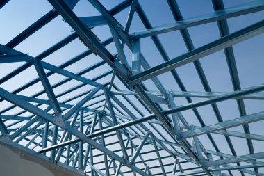 Structure of steel roof frame for building construction isolated on blue sky background. clipart