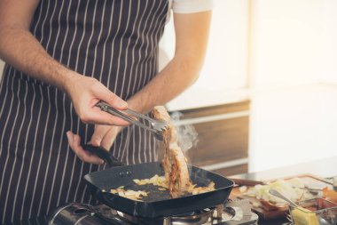 Yakın çekim adam biftek pişirme.