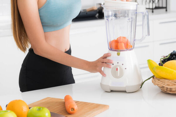 Close-up woman making fruits and vegetables juices using blender