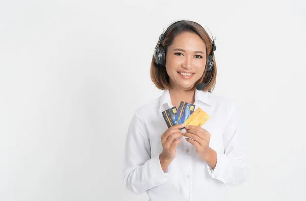 Centro de chamadas mulher com fone de ouvido segurando e cartão de crédito . — Fotografia de Stock