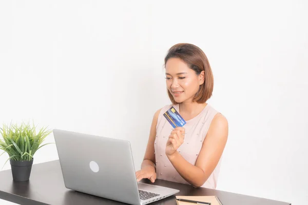 Mulher sorridente navegando em seu laptop e cartão de crédito . — Fotografia de Stock