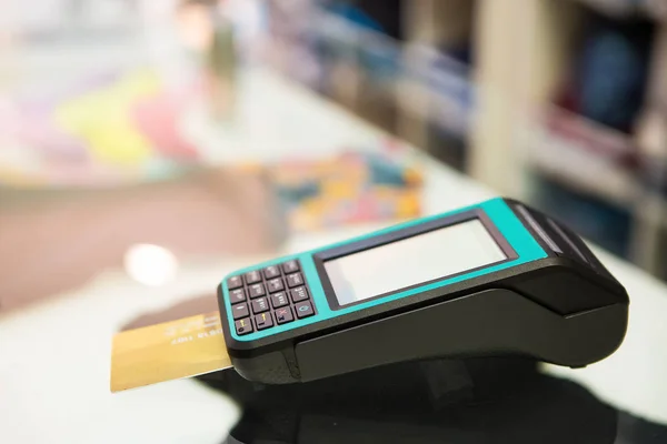 Credit card machine with bokeh background.