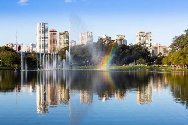 大批观看伊比拉普埃拉公园喷泉水滴形成的彩虹 背景是巴西圣保罗的豪华居民楼 — 图库照片