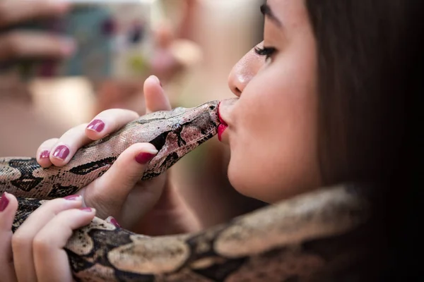 Chica besando una serpiente jiboia en su boca — Foto de Stock