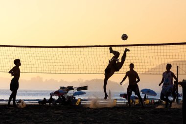 Plajda footvolley oynayan genç grup