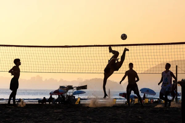 Grupo de jovens jogando footvolley na praia — Fotografia de Stock