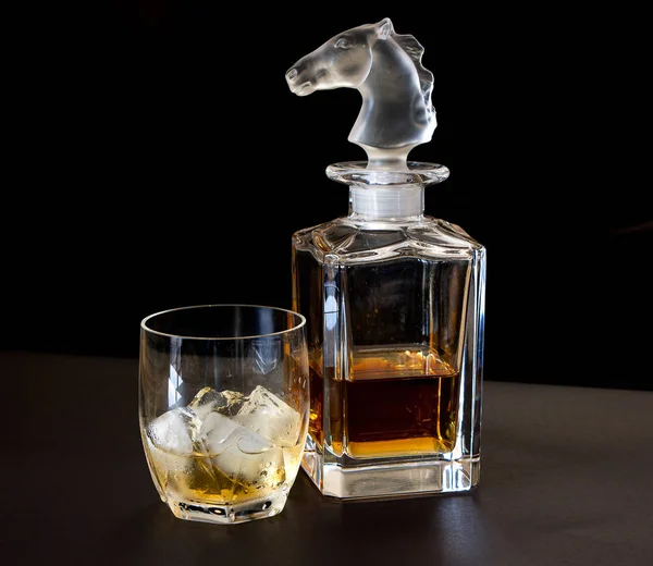 Hermosa botella de bebida con un vaso de whisky con hielo en un —  Fotos de Stock