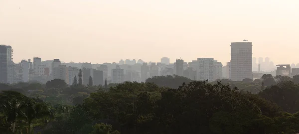 夕阳西下的圣保罗天际线，一架直升机降落在 — 图库照片