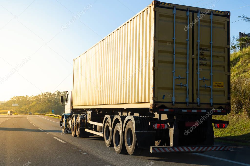 Truck transporting container on the road.