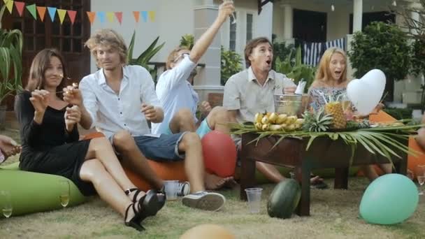 Щаслива група людей веселяться, посміхаються, запалюють блискавки — стокове відео