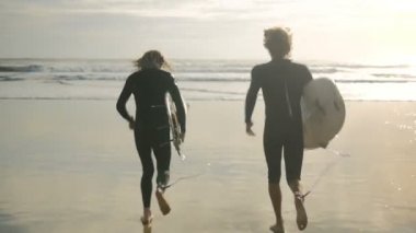 Sörf için okyanus dalgaları içine onların sörf tahtaları ile çalışan genç erkek sörfçü