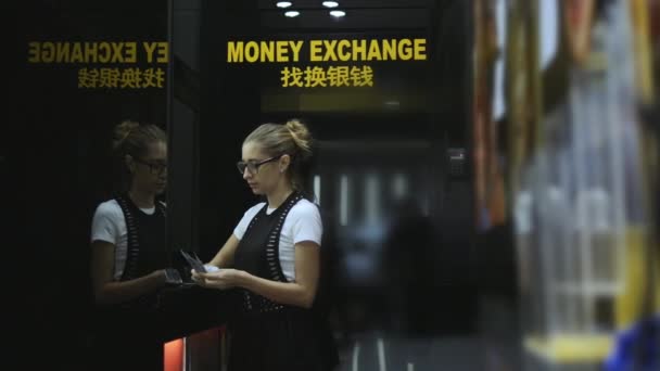 Wanita muda menghitung uang tunai dalam titik pertukaran mata uang — Stok Video