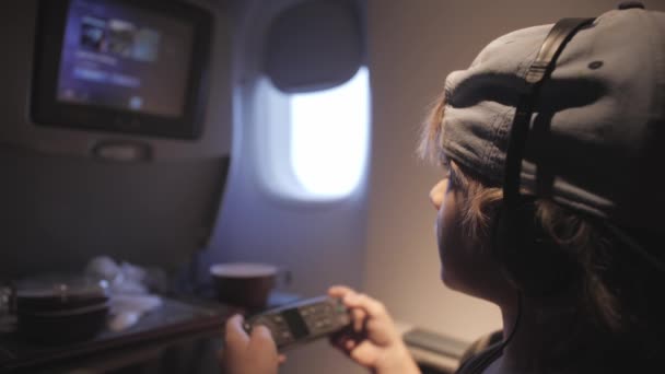 Aranyos gyermek játszik játékok, néz film utazik repülővel. — Stock videók