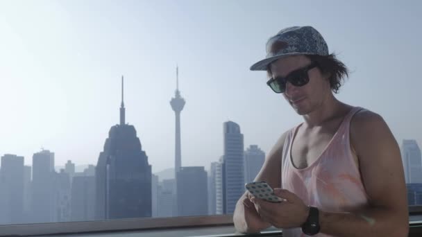 Freelancer using smartphone on modern city background. — Stock Video
