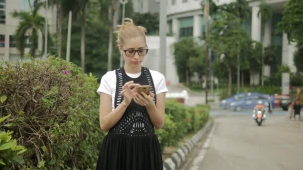 Ελκυστικό κορίτσι χρησιμοποιώντας το κινητό τηλέφωνο για να βρείτε μια διεύθυνση με ένα πλοηγό GPS — Αρχείο Βίντεο