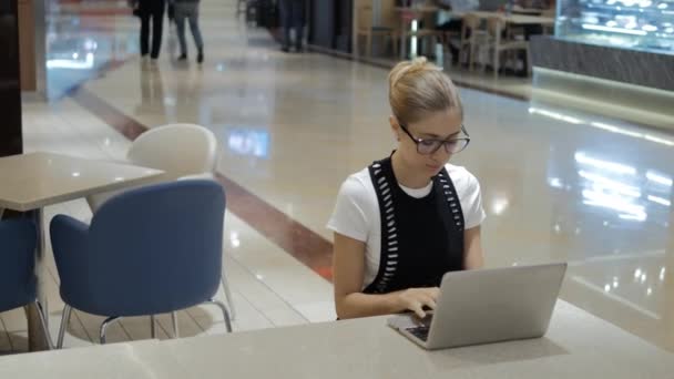 Joven freelancer atractivo usando laptop en espacio abierto . — Vídeo de stock