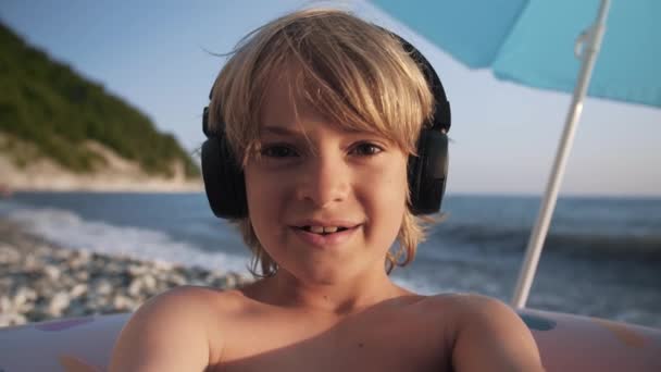 Bonito chats de vídeo infantil no telefone inteligente na praia — Vídeo de Stock