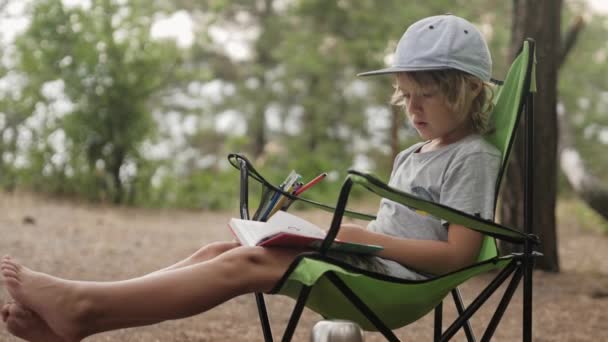 Kind liest ein Buch auf Holz-Hintergrund. — Stockvideo