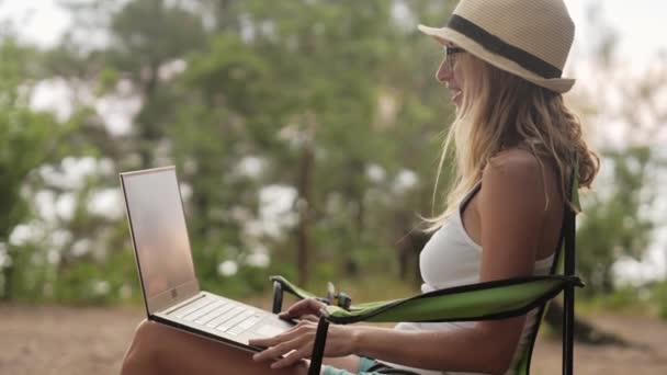 Ragazza sorridente che lavora sul computer portatile all'aperto in vacanza estiva . — Video Stock